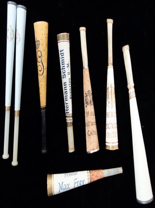 A collection of 24 paper and celluloid cigarette holders including some advertising