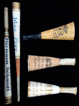 A collection of 24 paper and celluloid cigarette holders including some advertising